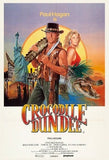 Movie poster for 'Crocodile Dundee' featuring a man with a gun, a woman, and a crocodile.
