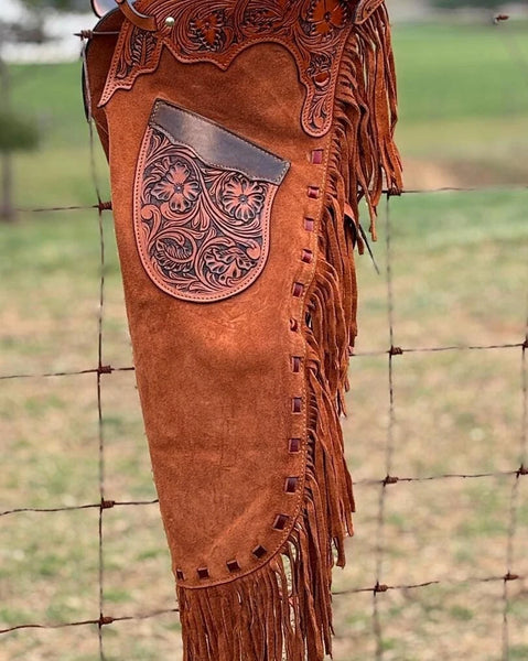 Premium hand-tooled leather chaps with fringe, designed in Native American western style for bull riding and rodeo competitions. Custom-fit cowboy gear built for durability and style