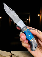 Close-up of the 3-inch Damascus steel blade of the Blue Ridge Pocket Knife, showcasing its unique patterns and durability