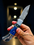 Detailed view of the blue and black exotic wood handle of the Blue Ridge Damascus Pocket Knife, highlighting its elegance and ergonomic design
