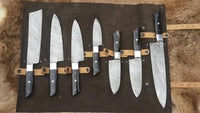 A set of seven custom kitchen knives with Damascus steel blades and buffalo horn handles displayed on a leather roll.